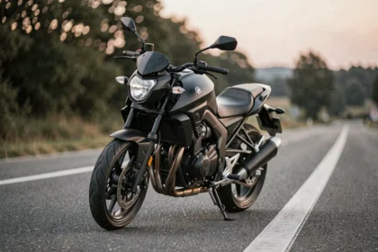 Yamaha MT-125 noire sur route asphaltée en accélération, vue 3/4 avant avec bokeh de campagne