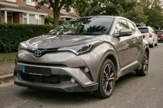 Toyota C-HR garé dans une rue résidentielle montrant des traces d'usure réaliste après un essai longue durée